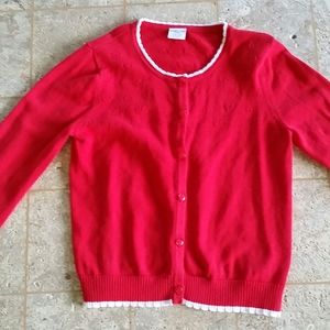 A button-down red sweater with white ruffles.